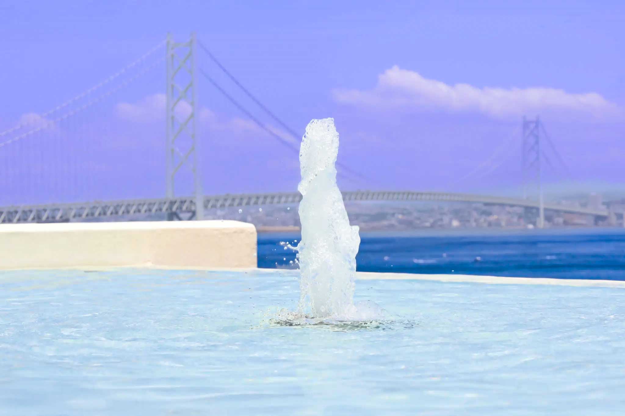 淡路島の海と明石海峡大橋を背景に、２階のインフィニティプールが広がるCORAL SUITE VILLA awajiのテラス。